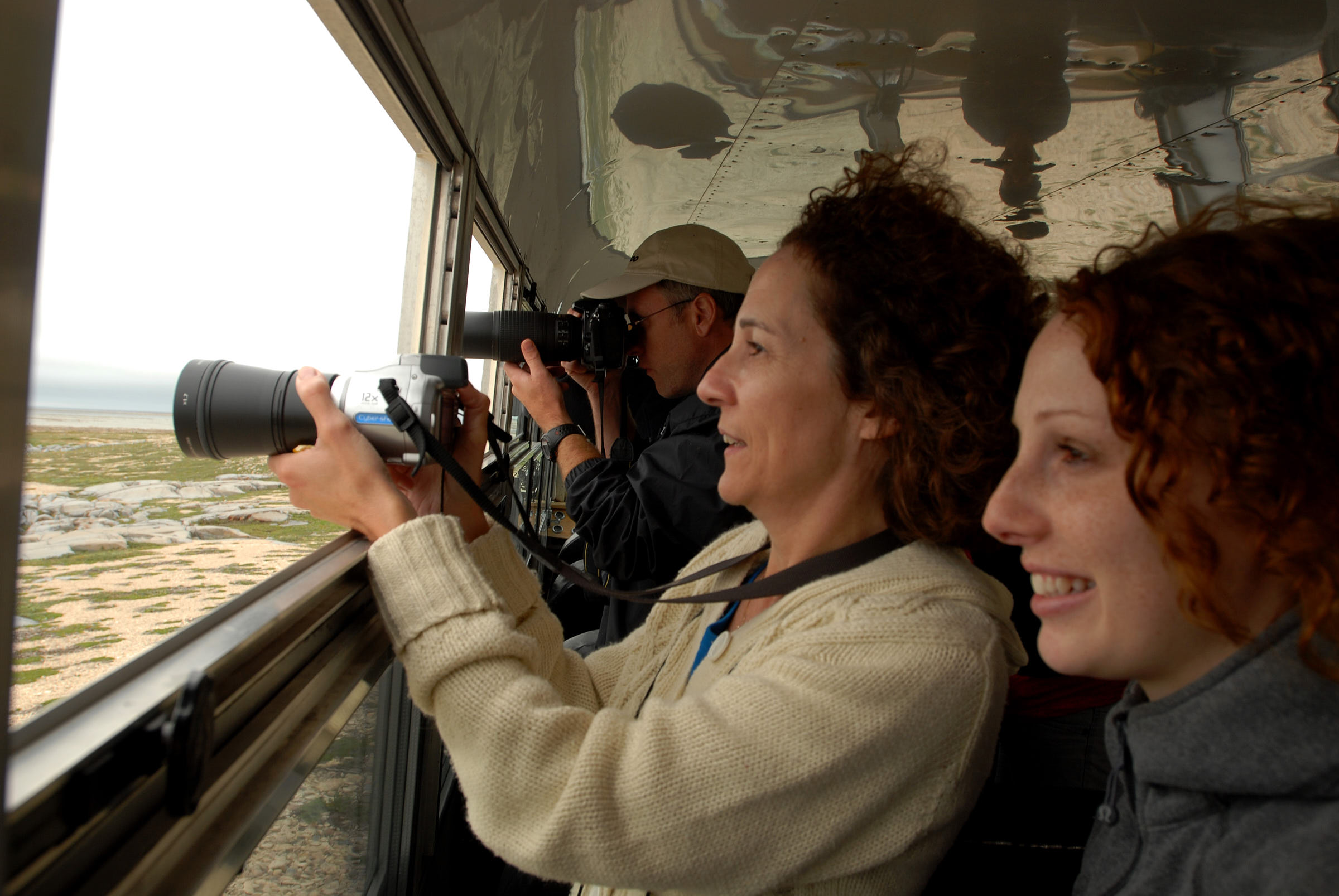 Frontiers North guests taking photos out of the window of the Tundra Buggy