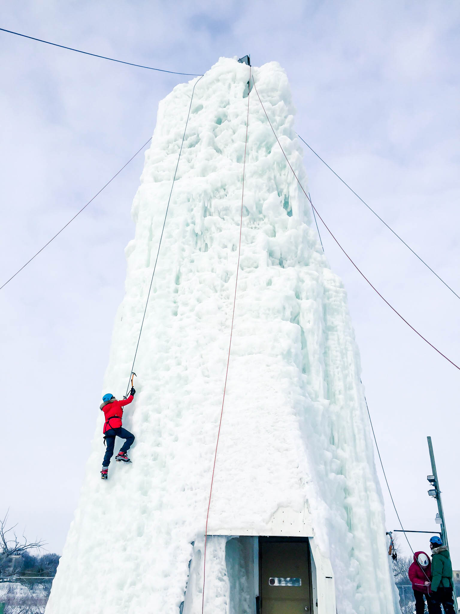 A person climbing up a man-made ice tower