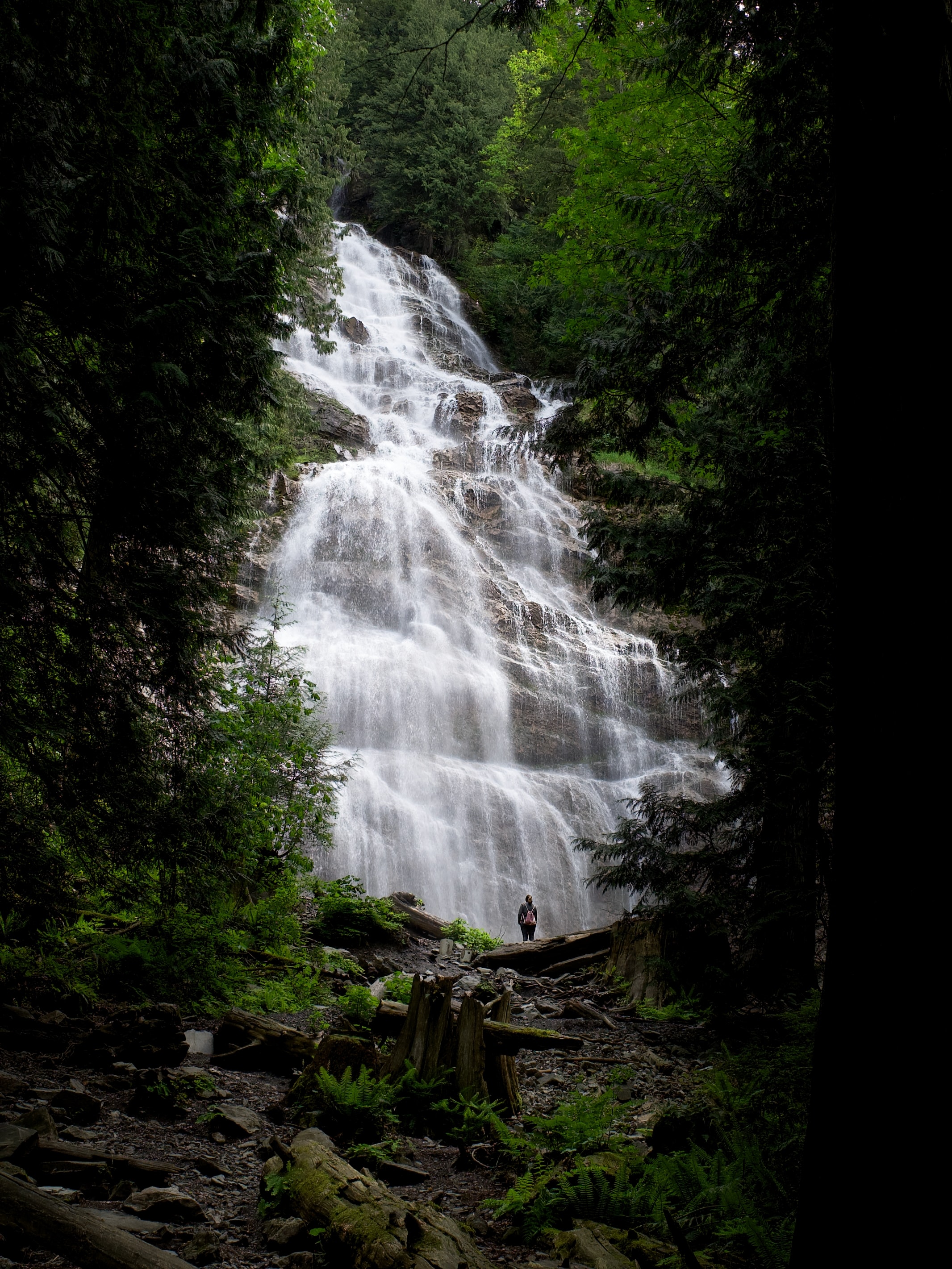 A person looking up at a waterfall
