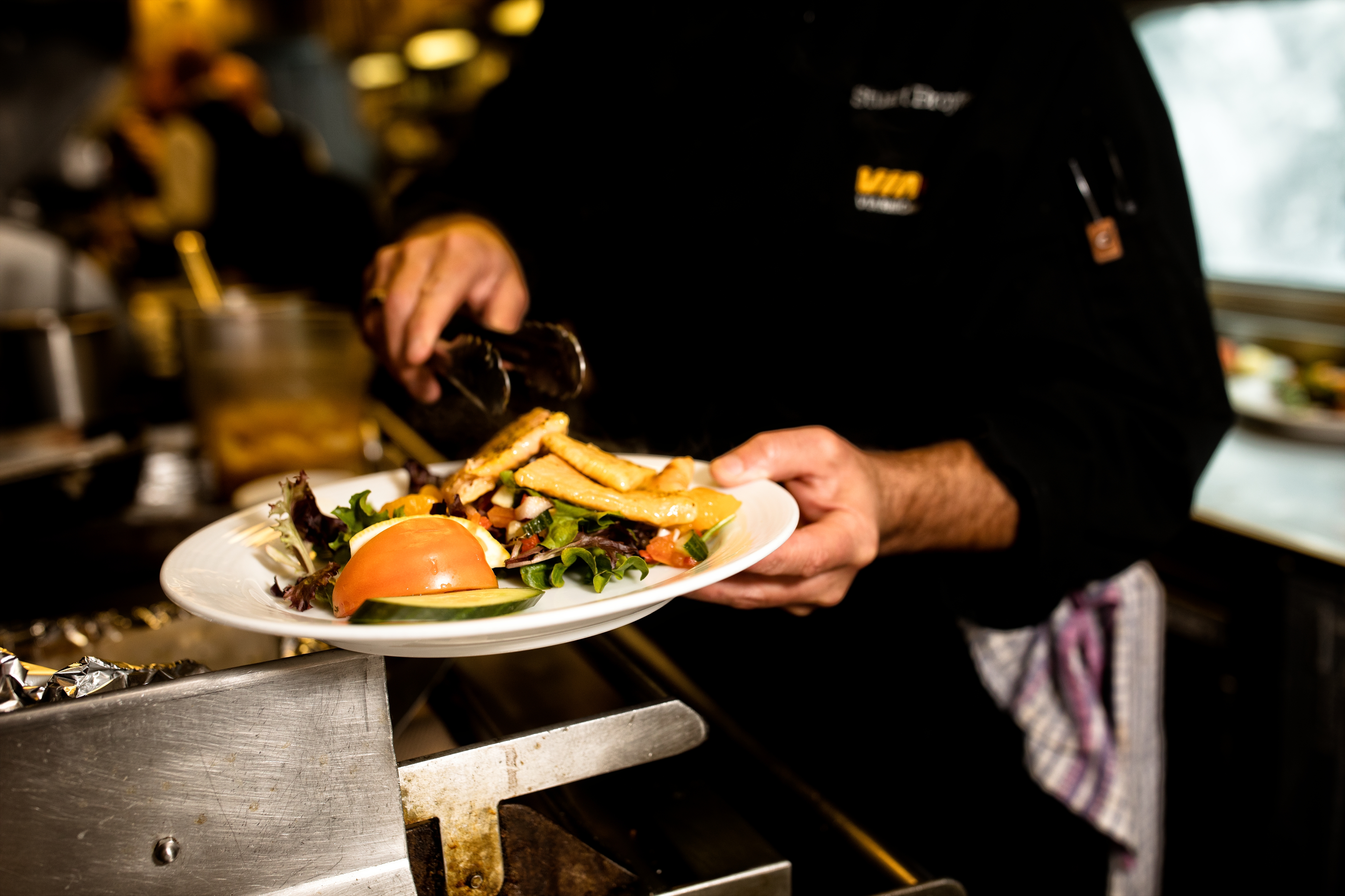 A meal getting plated in a train car kitchen