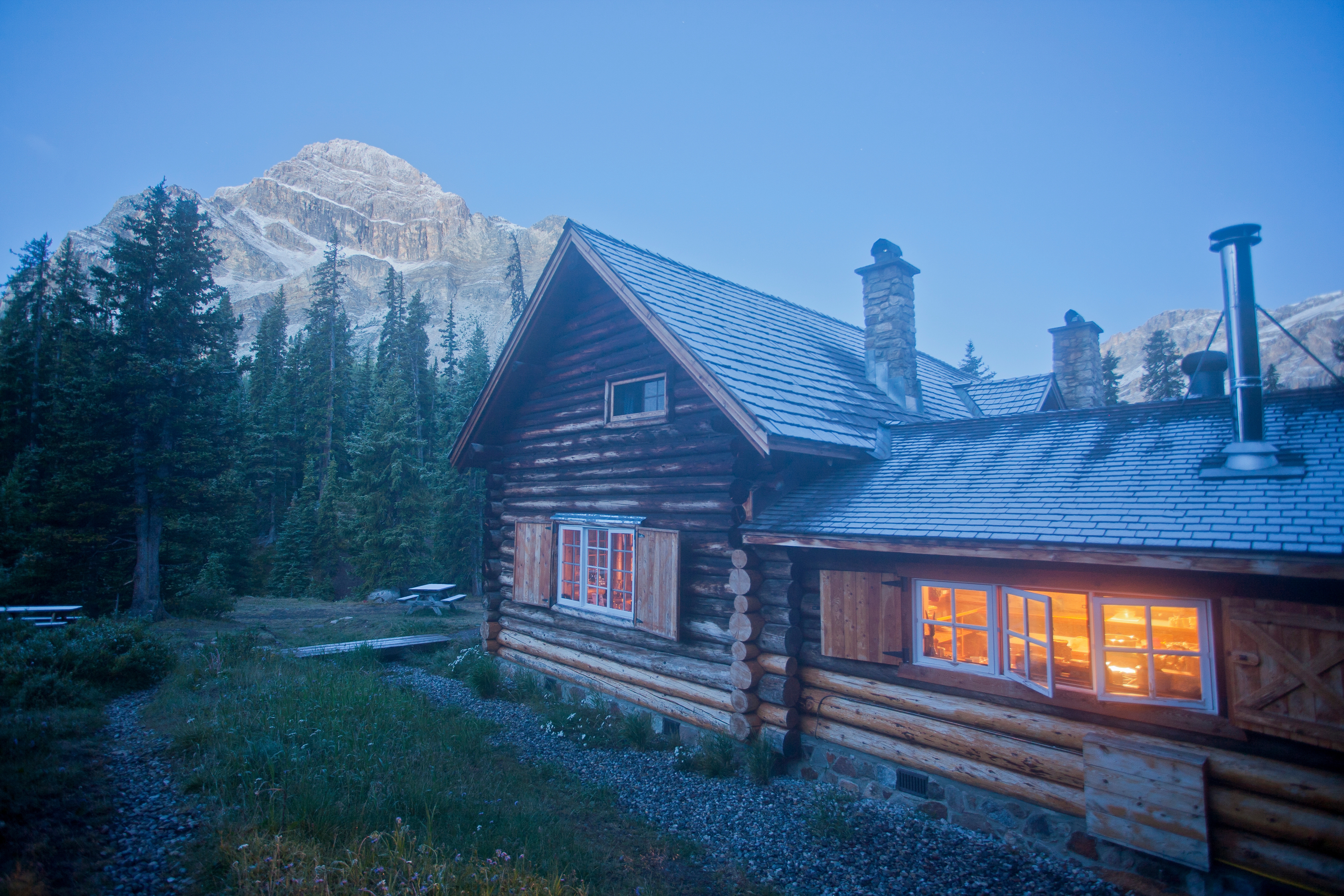Heritage backcountry log cabin, Skoki Lodge, by the mountains in the evening