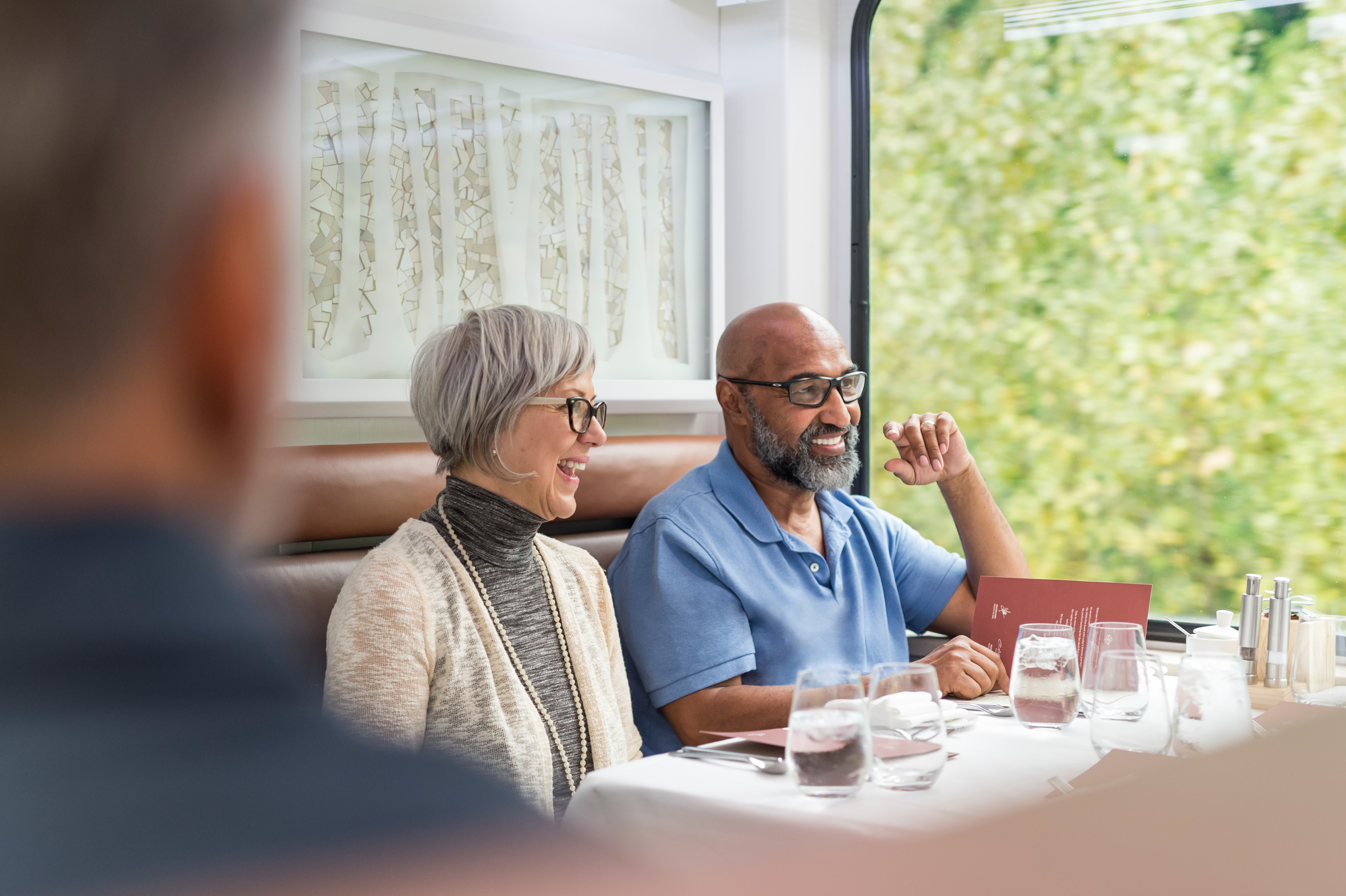 Guests enjoying wine before lunch in GoldLeaf dining room onboard the train