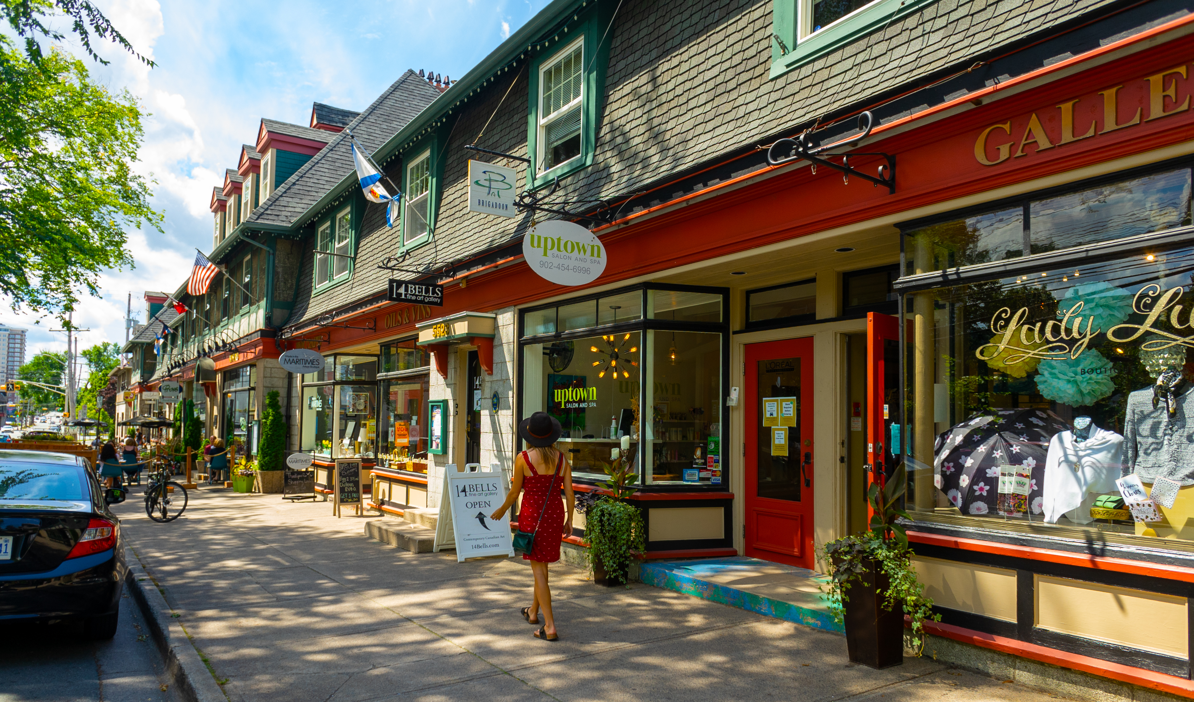 A woman walks past colourful art galleries, spas and shops