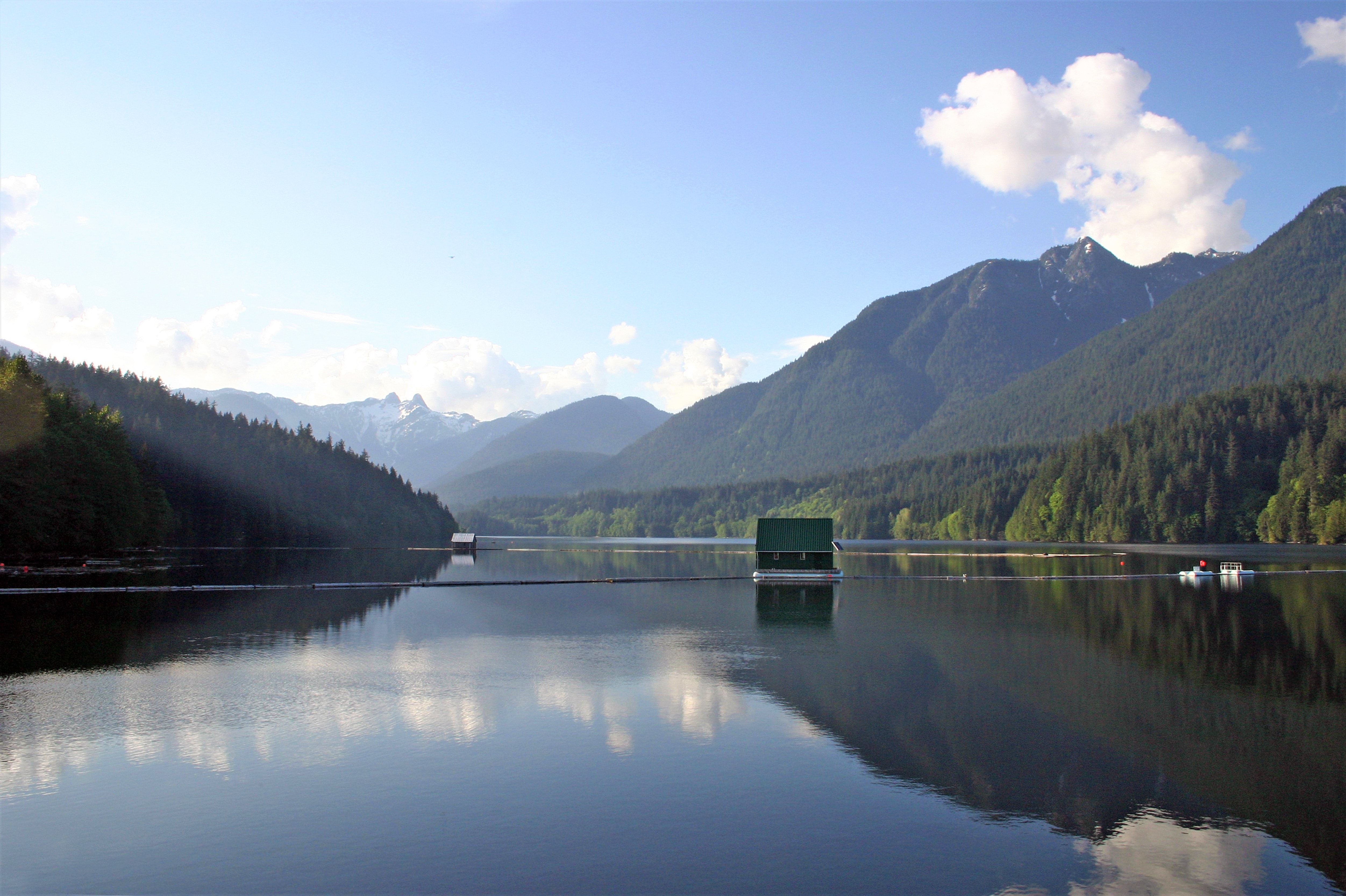 Green boathouse floating on Capilano Lake on the North Shore
