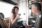Man and woman enjoy a cup of coffee in VIA sleeper car