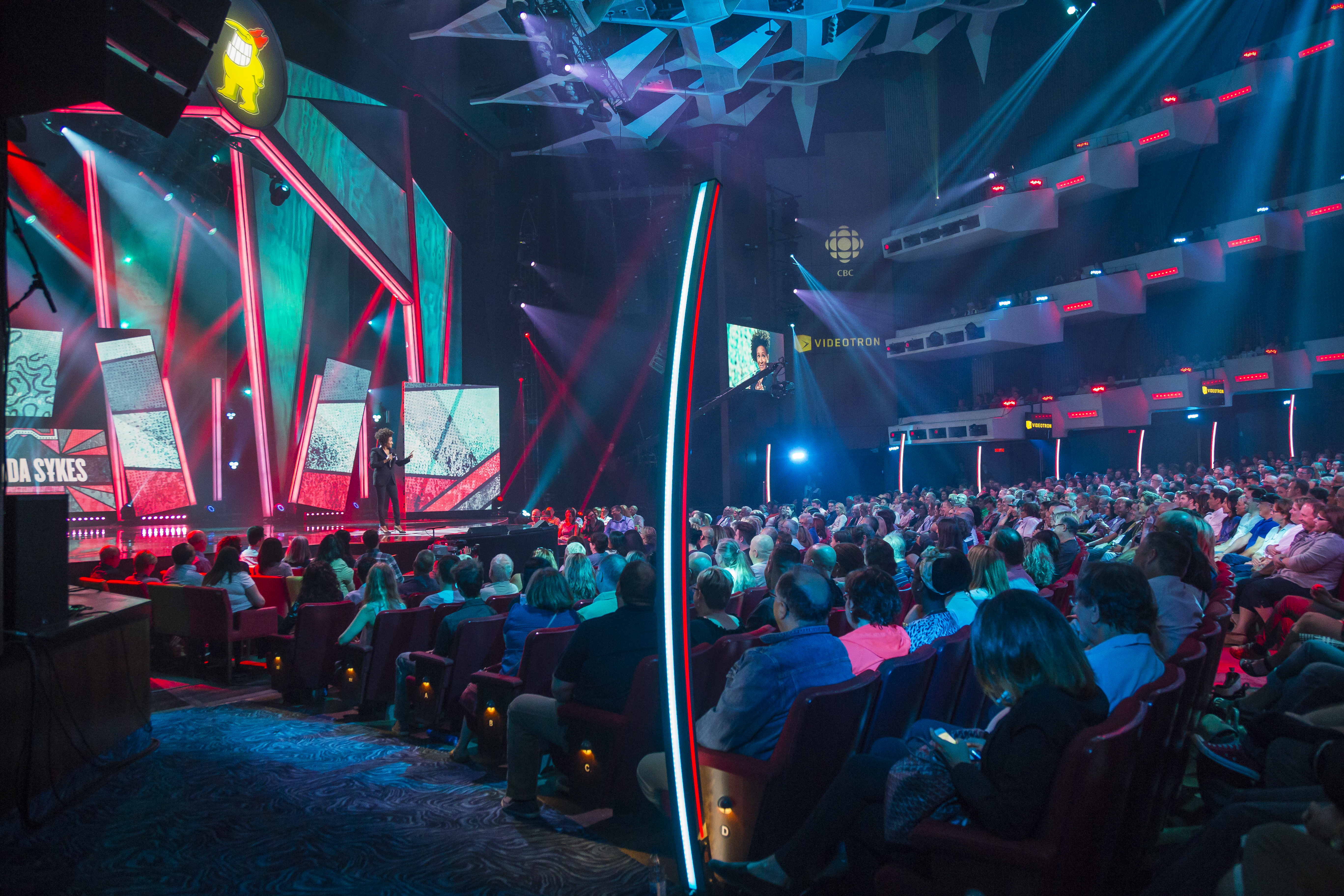 People watching a comedy show in a theatre with modern lighting