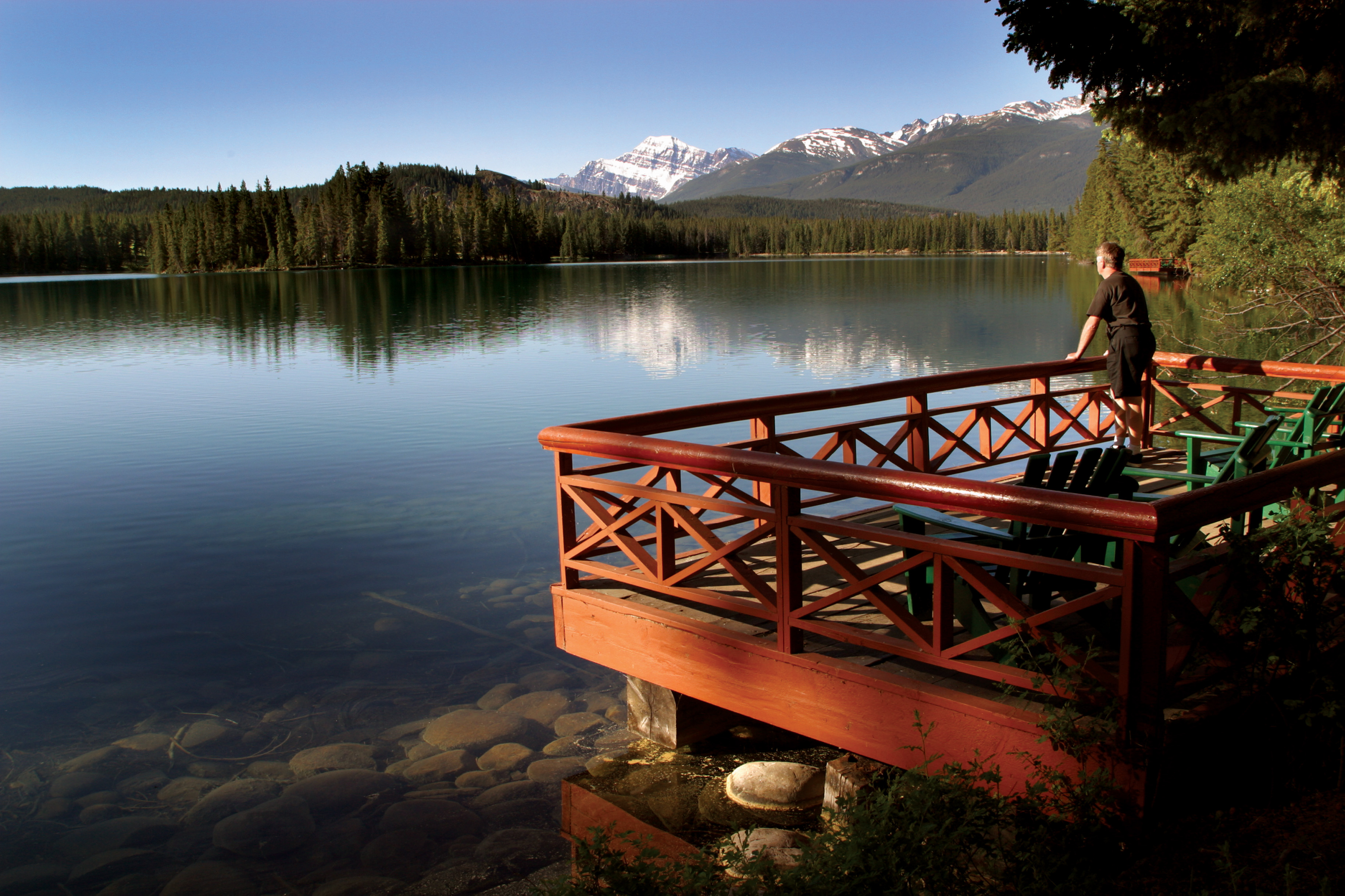 Man looks out in the direction of Hector Lake from Fairmont Park Lodge in Jasper, Alberta