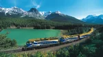 Rocky Mountaineer train running through mountains and lake
