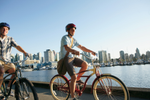 Two people cycling on the sea wall in Vancouver on a summer’s day