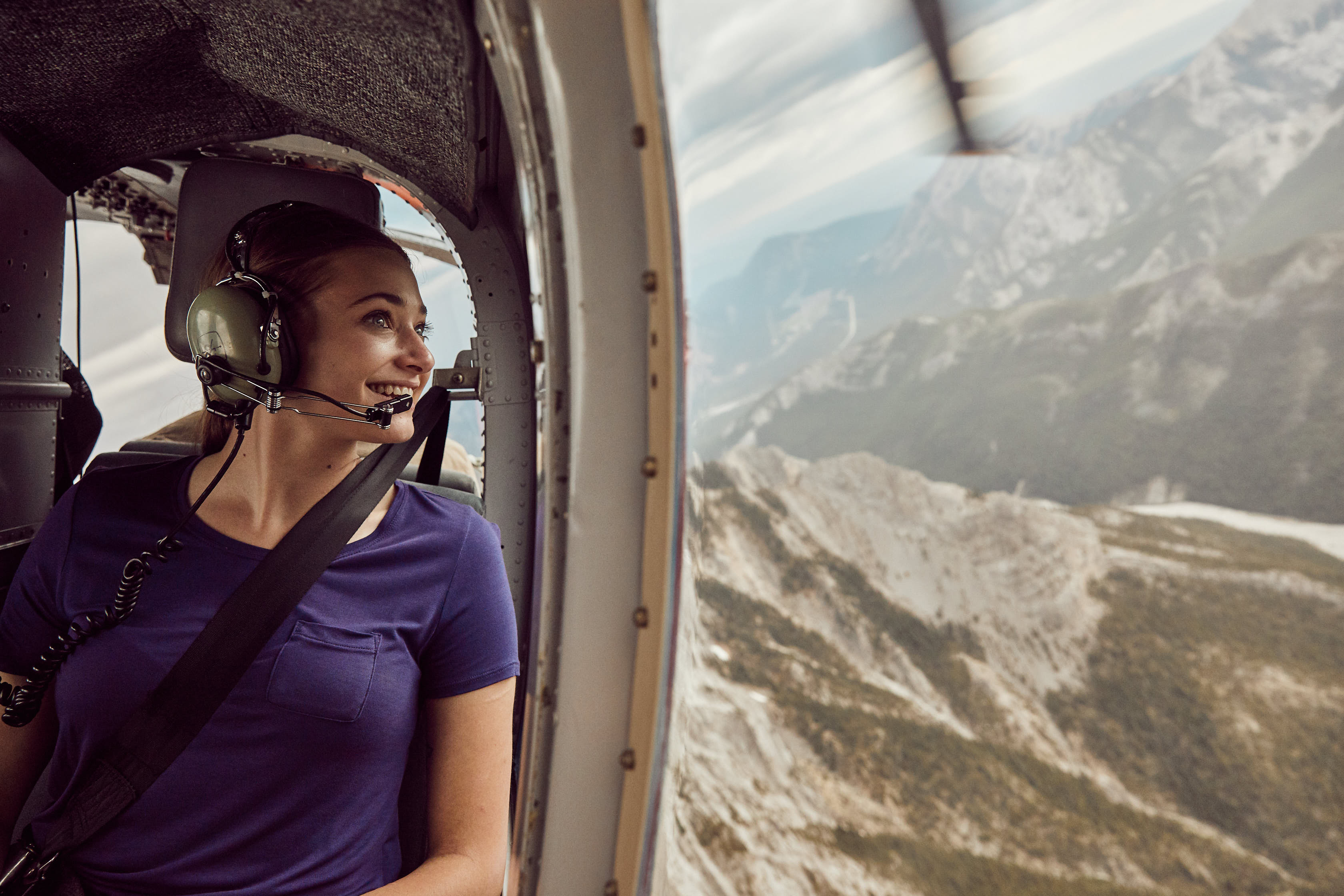 A tourist looks out the window during a helicopter tour in the Rockies