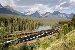 Rocky Mountaineer train going through Banff National park with mountains