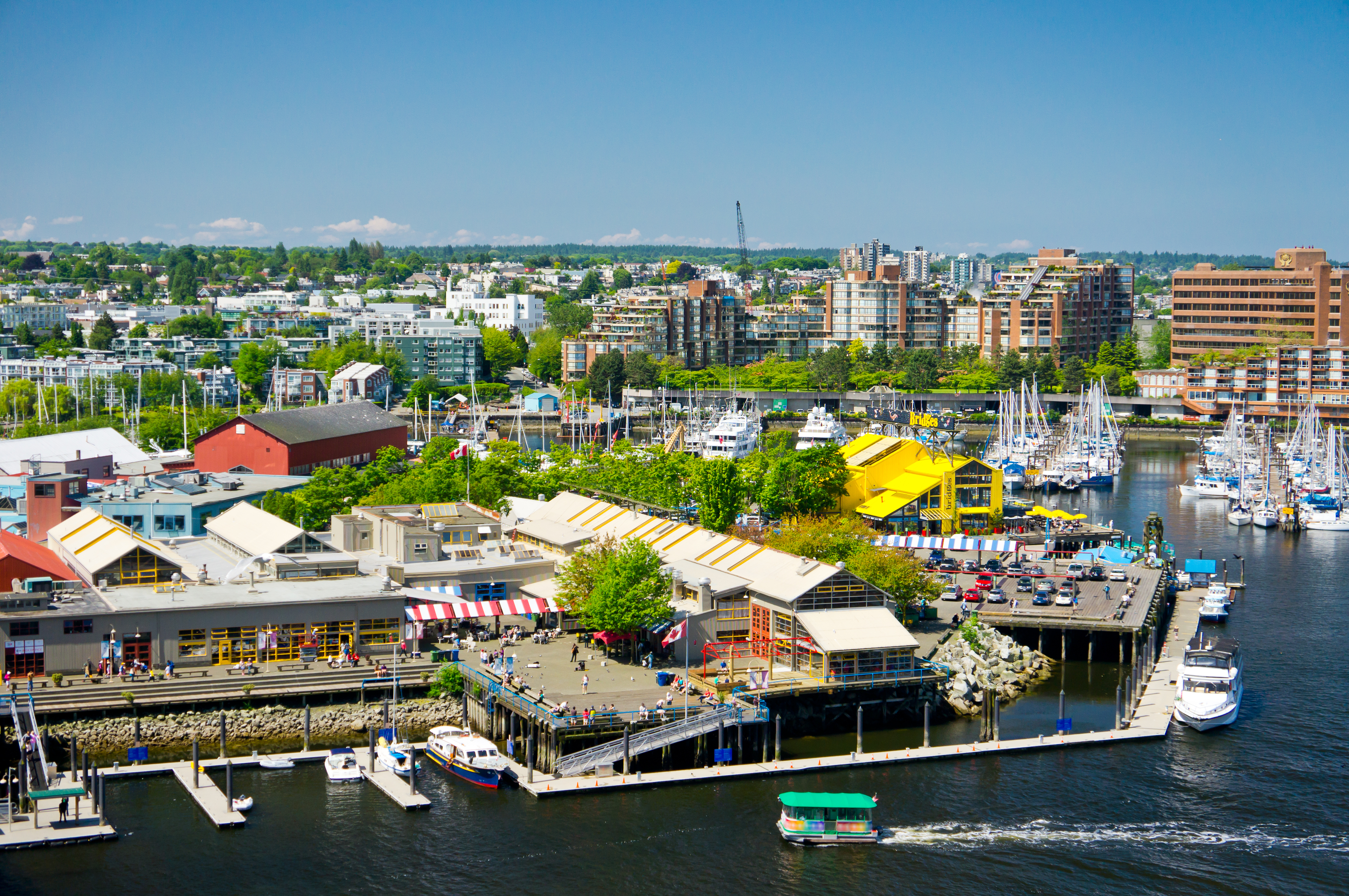Aerial view of Granville Island shops, market and marina with boats and aquabus in front