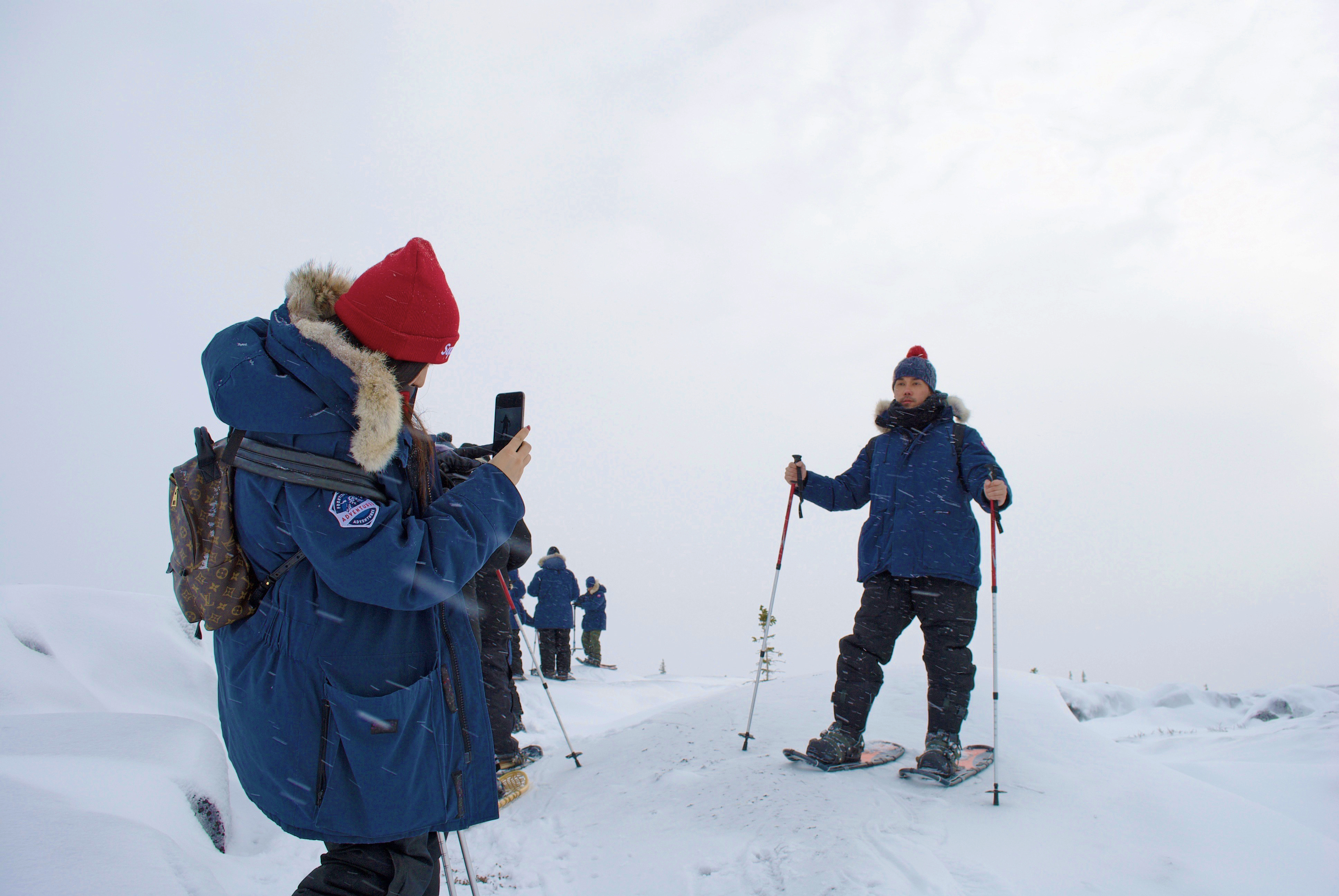 A person taking a picture of someone snowshoeing in Churchill Manitoba