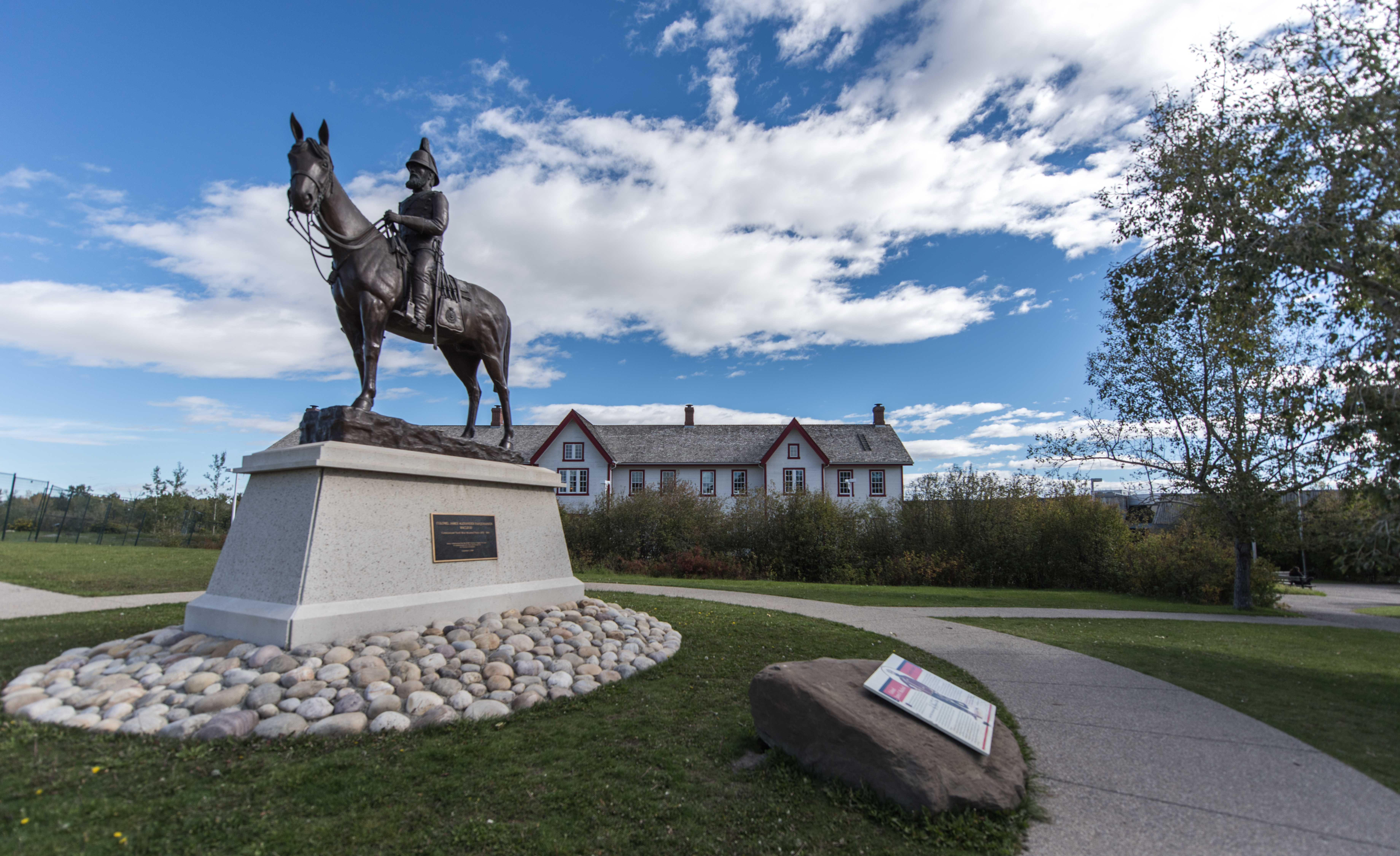 Horse and rider statue in front of a building at the Fort Calgary historic site
