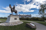 Horse and rider statue in front of a building at the Fort Calgary historic site