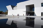 People walking outside the white building and reflecting pools of the Aga Khan Museum