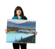 A person holding a large sign board with Canadian scenery on it