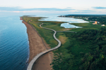 Boardwalk winds through coastal ecological site with natural saltwater beach in New Brunswick
