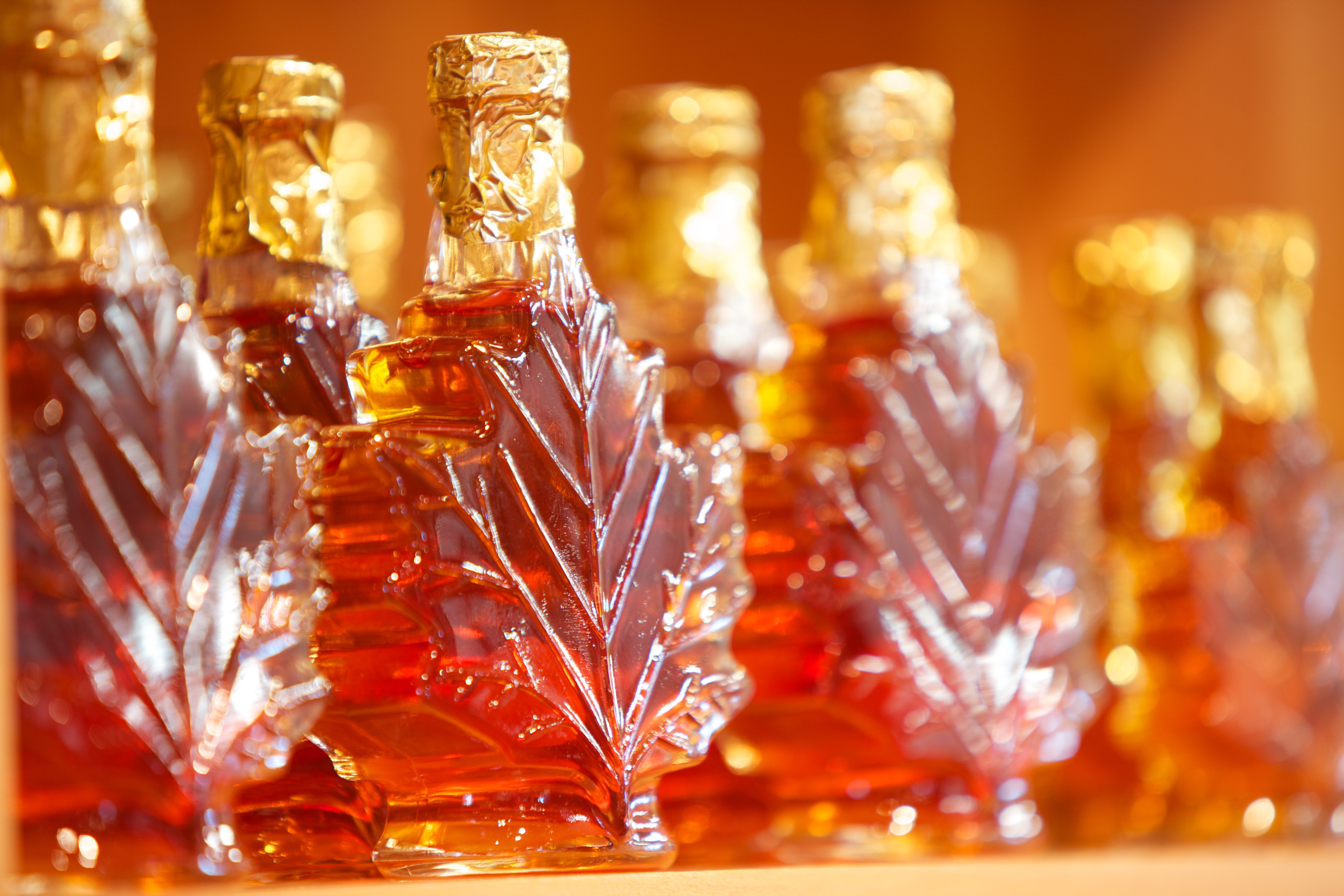 Close up view of maple syrup bottles in the shape of maple leaves