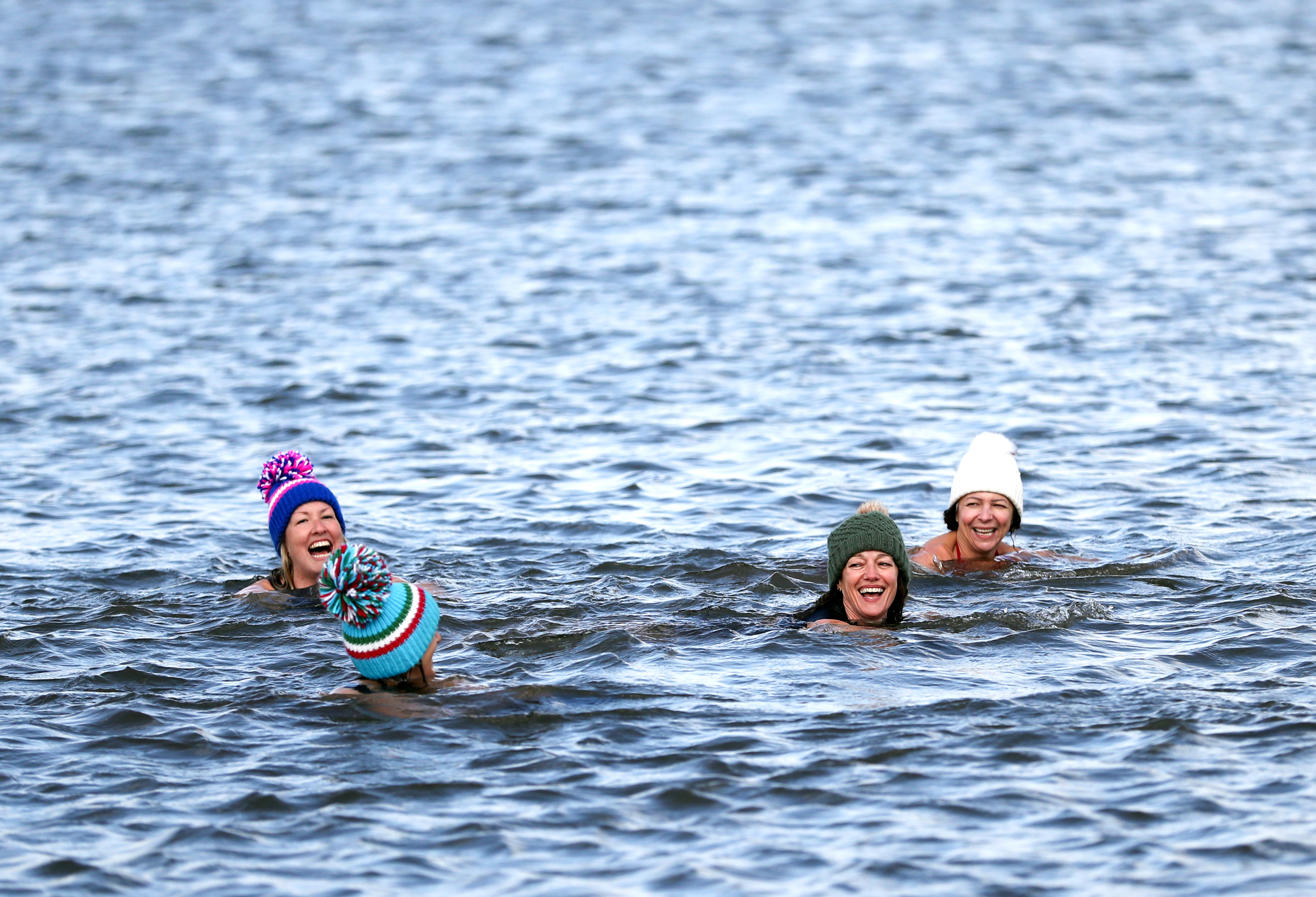 Four women swimming in the cold ocean water