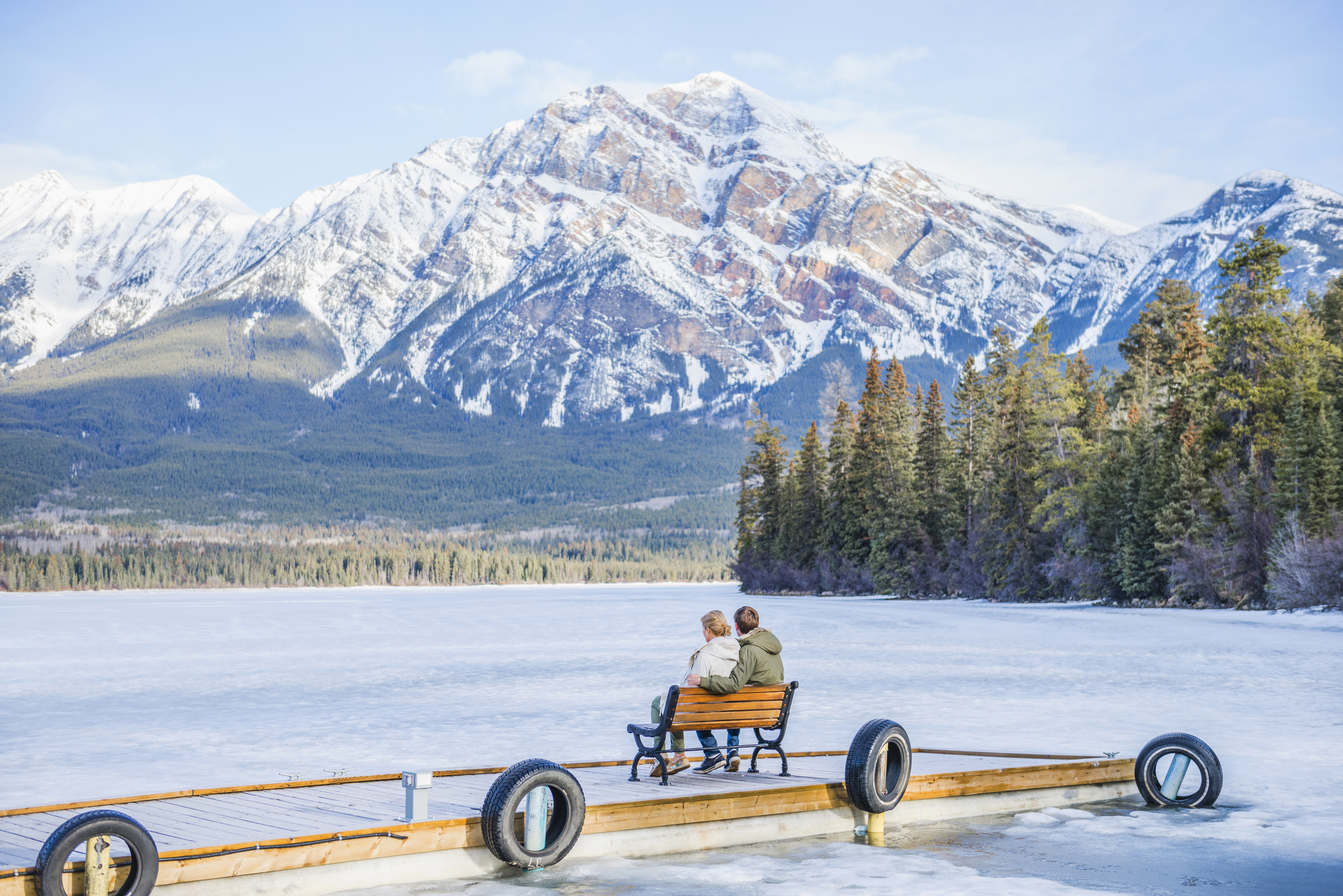 couple admiring scenic mountain view on wooden dock, Jasper