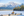 Couple sitting on a bench on a dock looking at snowy mountains
