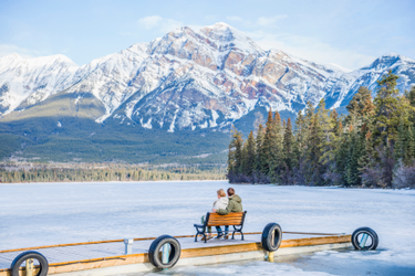 couple admiring scenic mountain view on wooden dock, Jasper