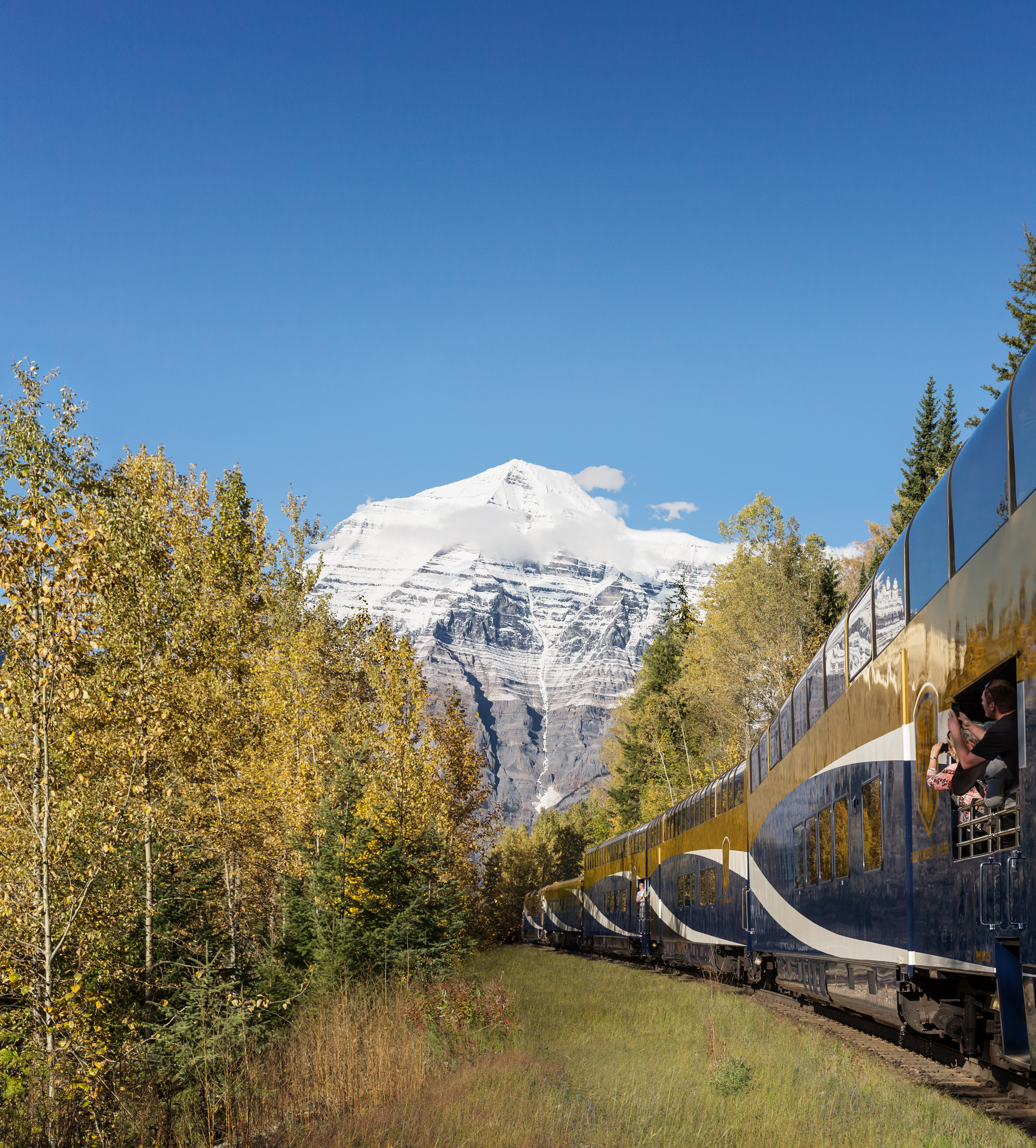 Guests capturing photos of Mount Robson from the GoldLeaf service vestibule on the Journey Through the Clouds route