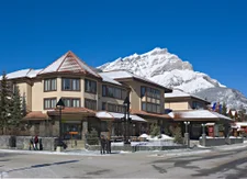 Elk and Avenue Hotel in Banff with snow-capped mountains