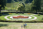 Landscaped gardens with a red maple leaf flowerbed in the centre