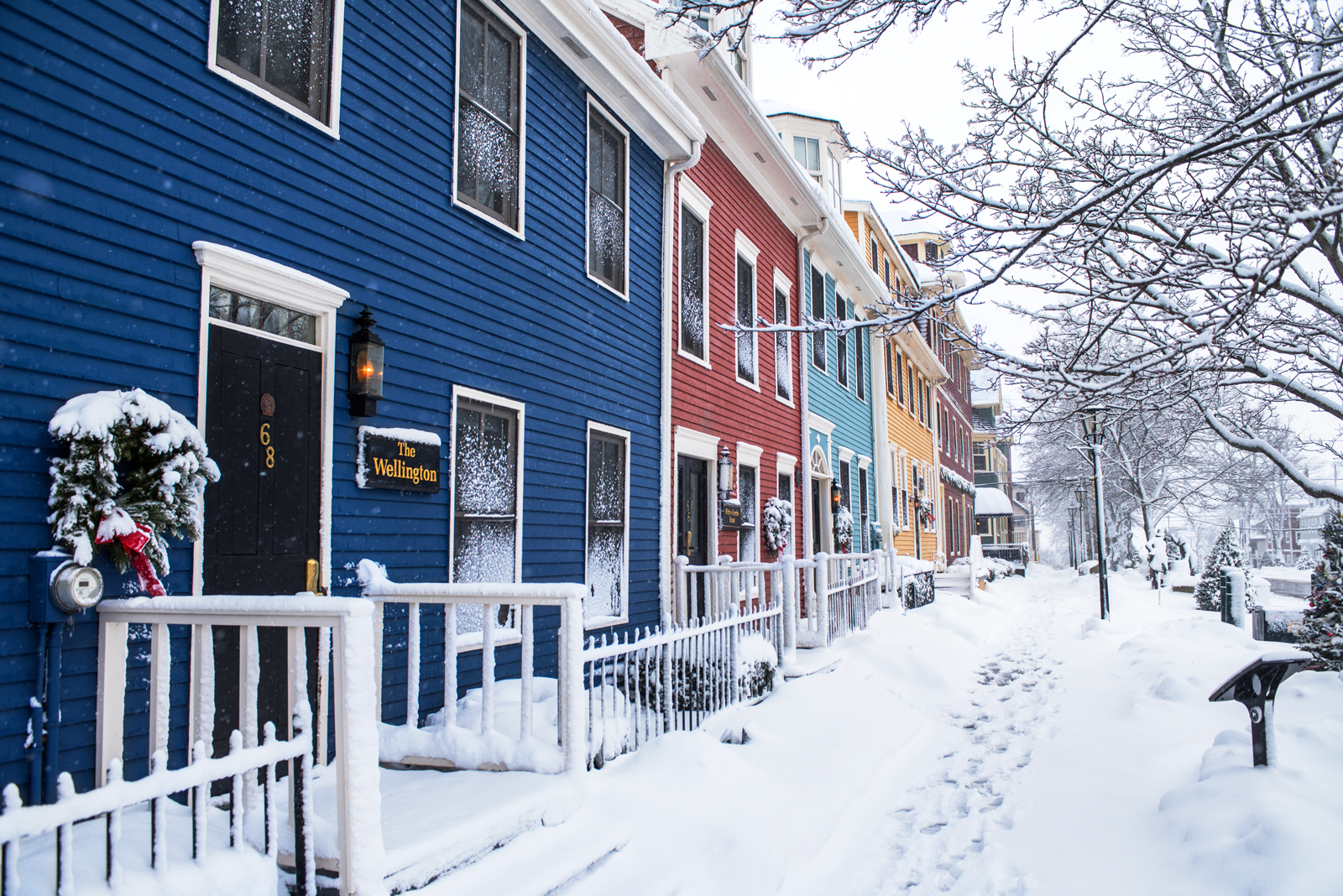 A street of colourful houses covered in snow
