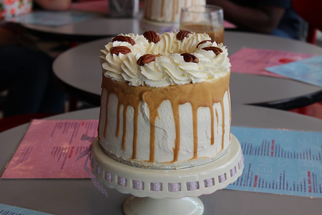 Schmoo torte cake sitting on a cake stand placed on table