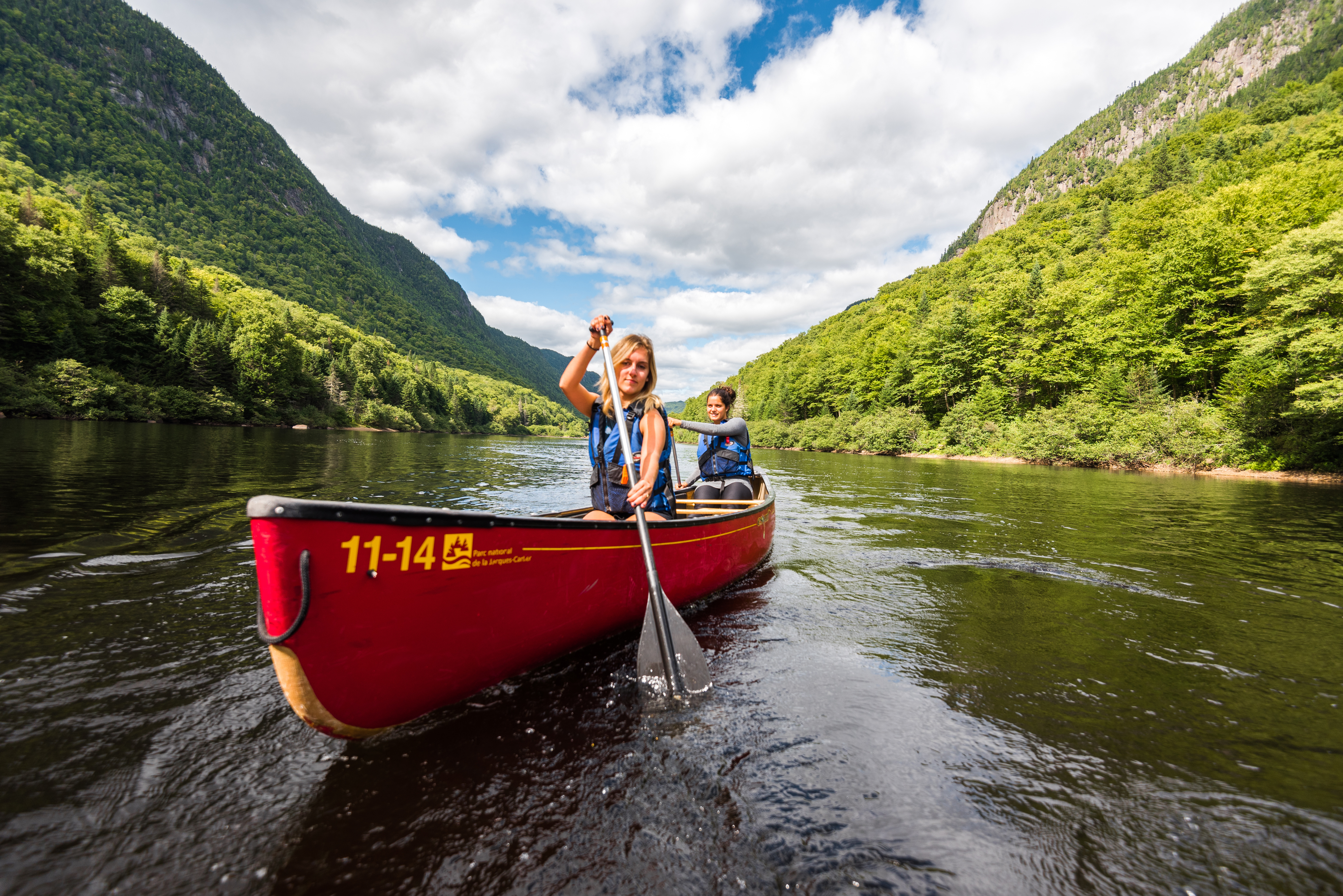A couple in a red canoe on a lake in Jacques-Cartier National Park