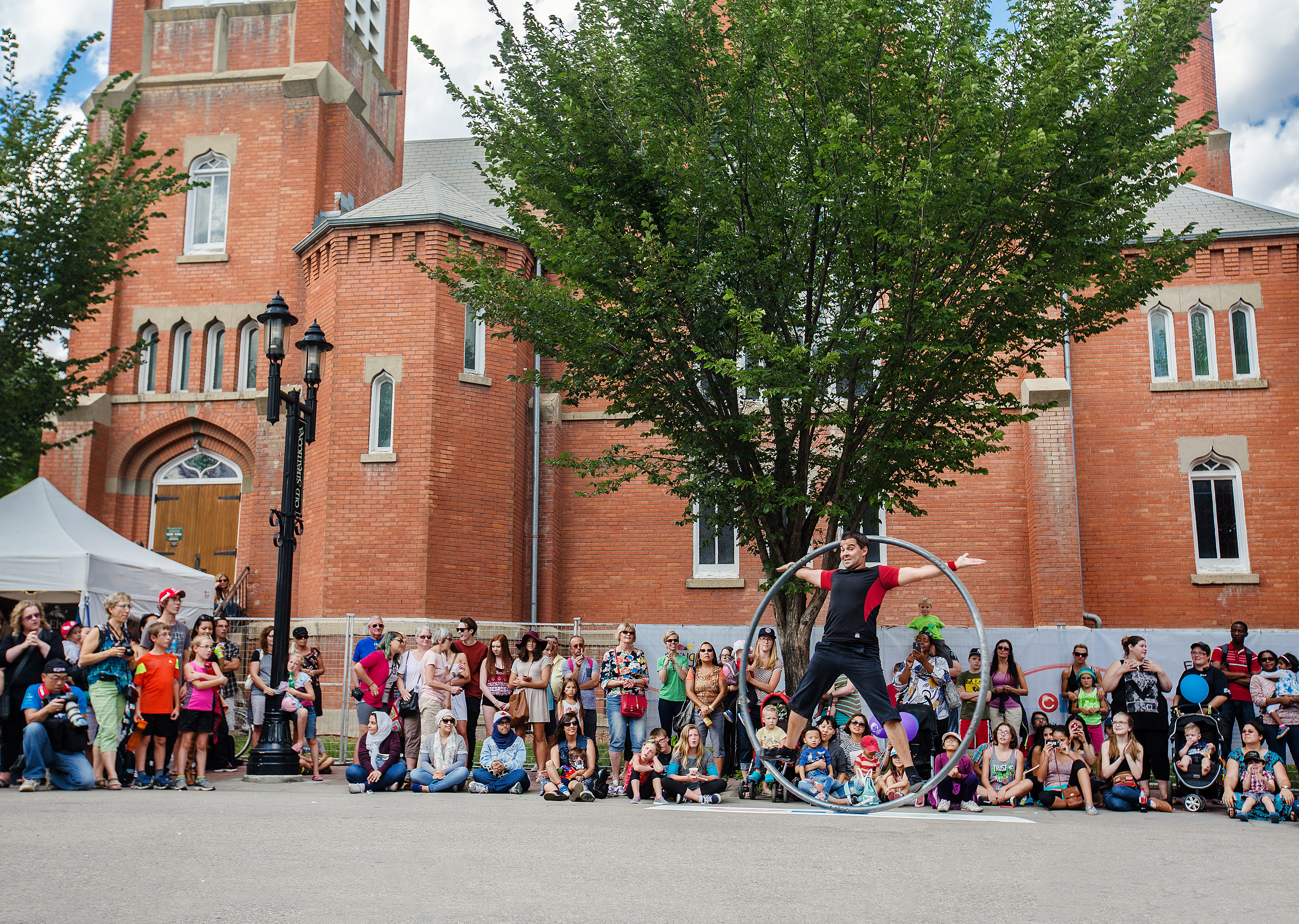 Spectators watching a performer outdoors at the Edmonton Fringe Festival