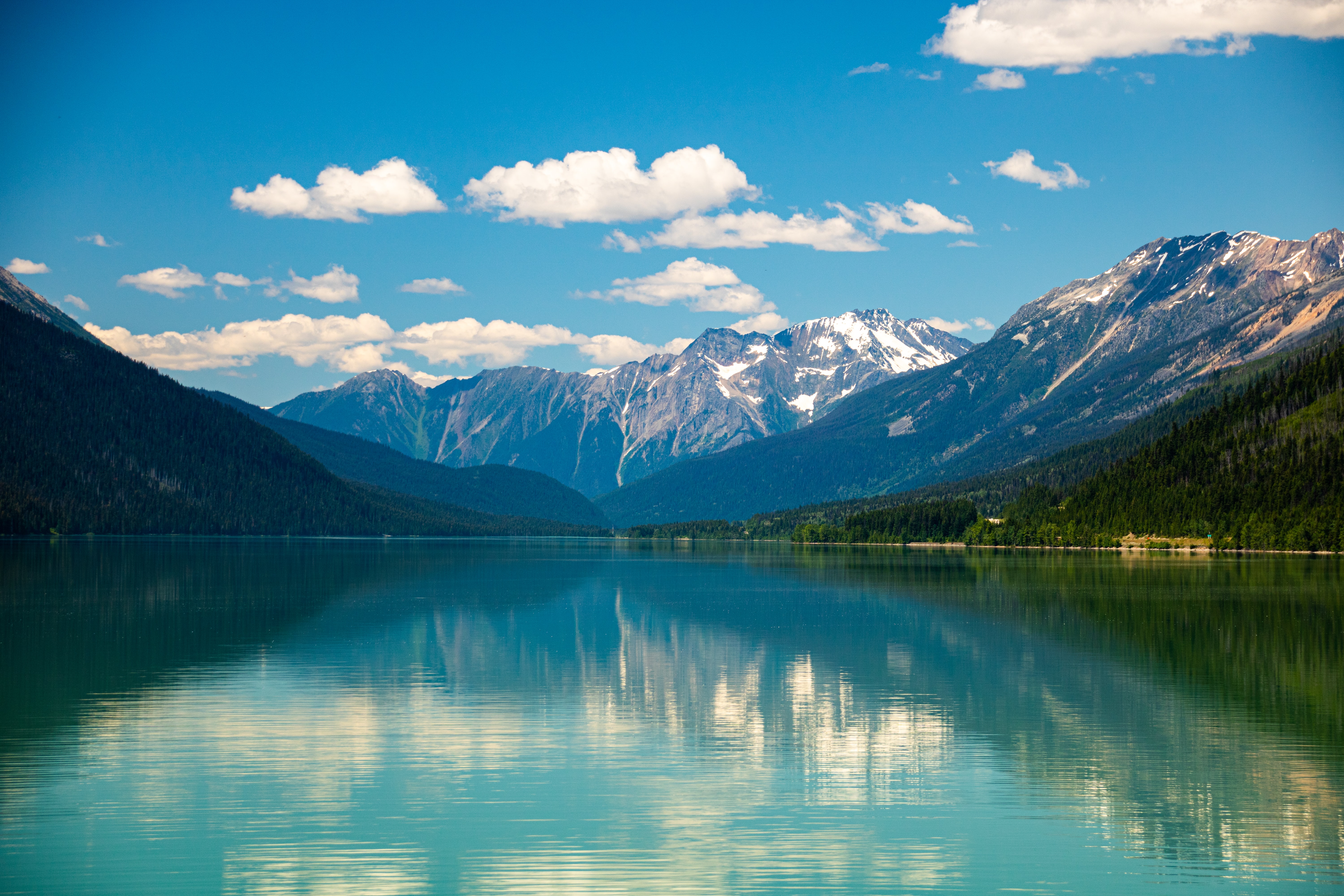 Mountains and sky reflected in the blue waters of Moose Lake in Jasper