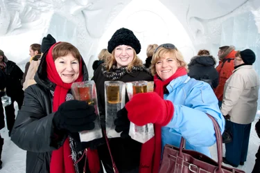 Three women holding ice glasses and saying cheers