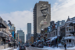 View down a snowy street in Montreal with the Leonard Cohen mural on a high rise building