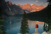 A hiker absorbs an amazing scene in the mountains in Banff