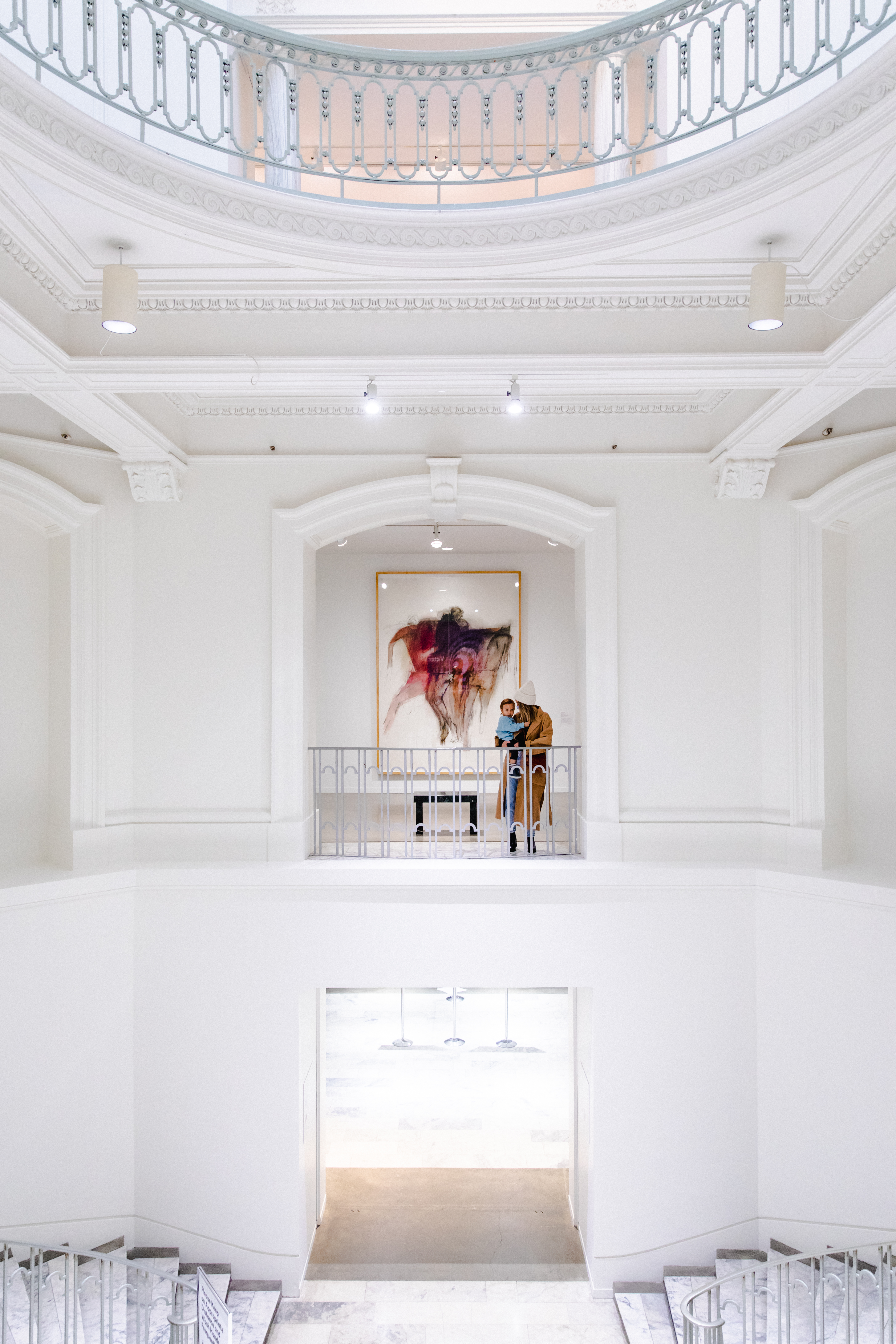 A woman and child standing in front of a painting inside the Vancouver Art Gallery