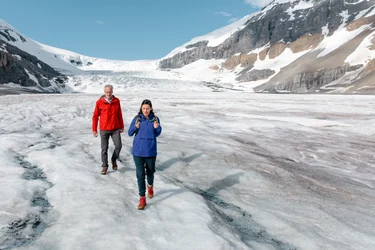 Couple walking down an icy glacier in the Canadian Rockies