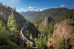 Rocky Mountaineer train travels through mountainous landscape and vast forests during journey