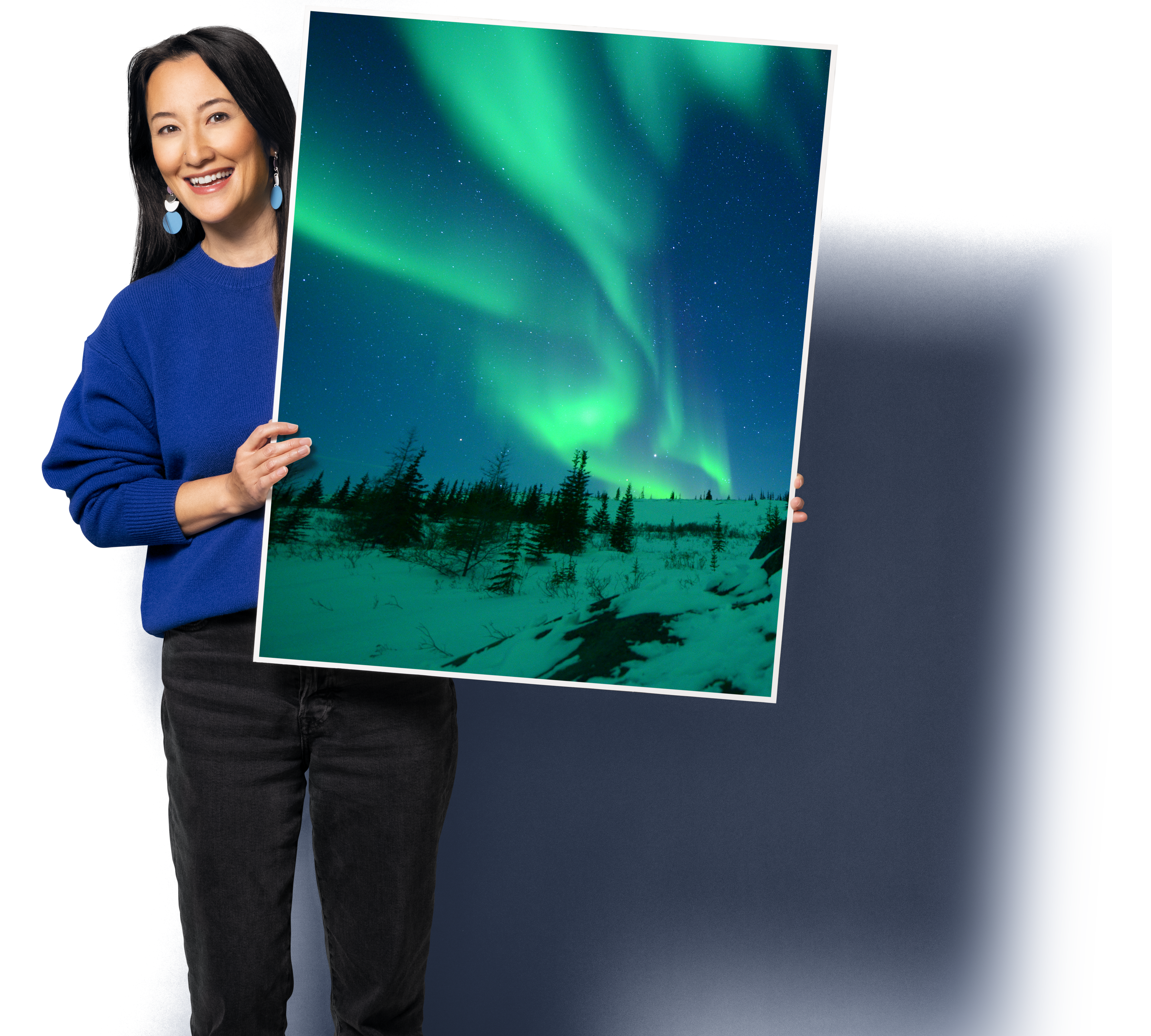 A person holding a large sign board with Canadian scenery on it