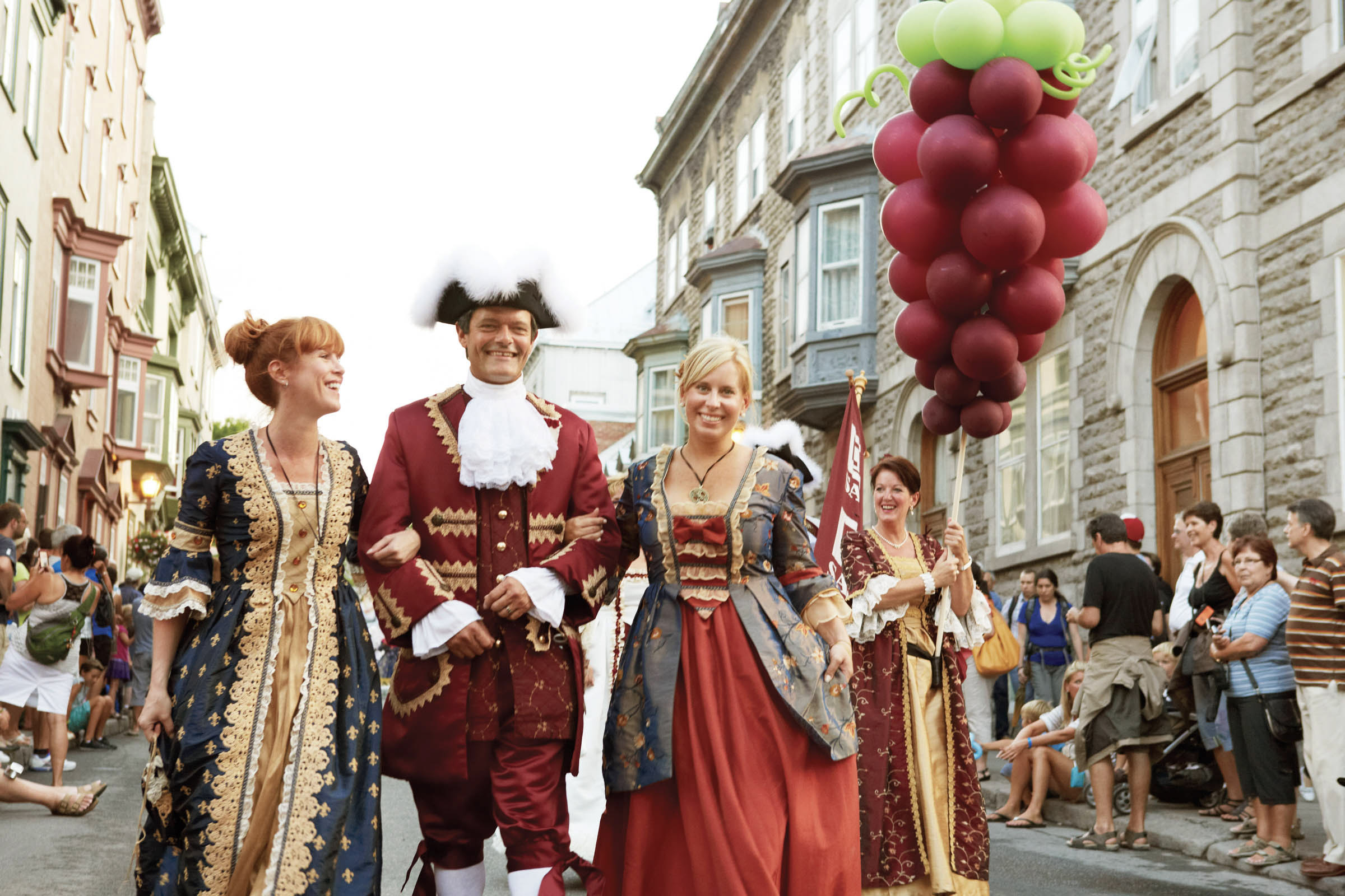 A group of three people dressed up in traditional French Canadian clothing