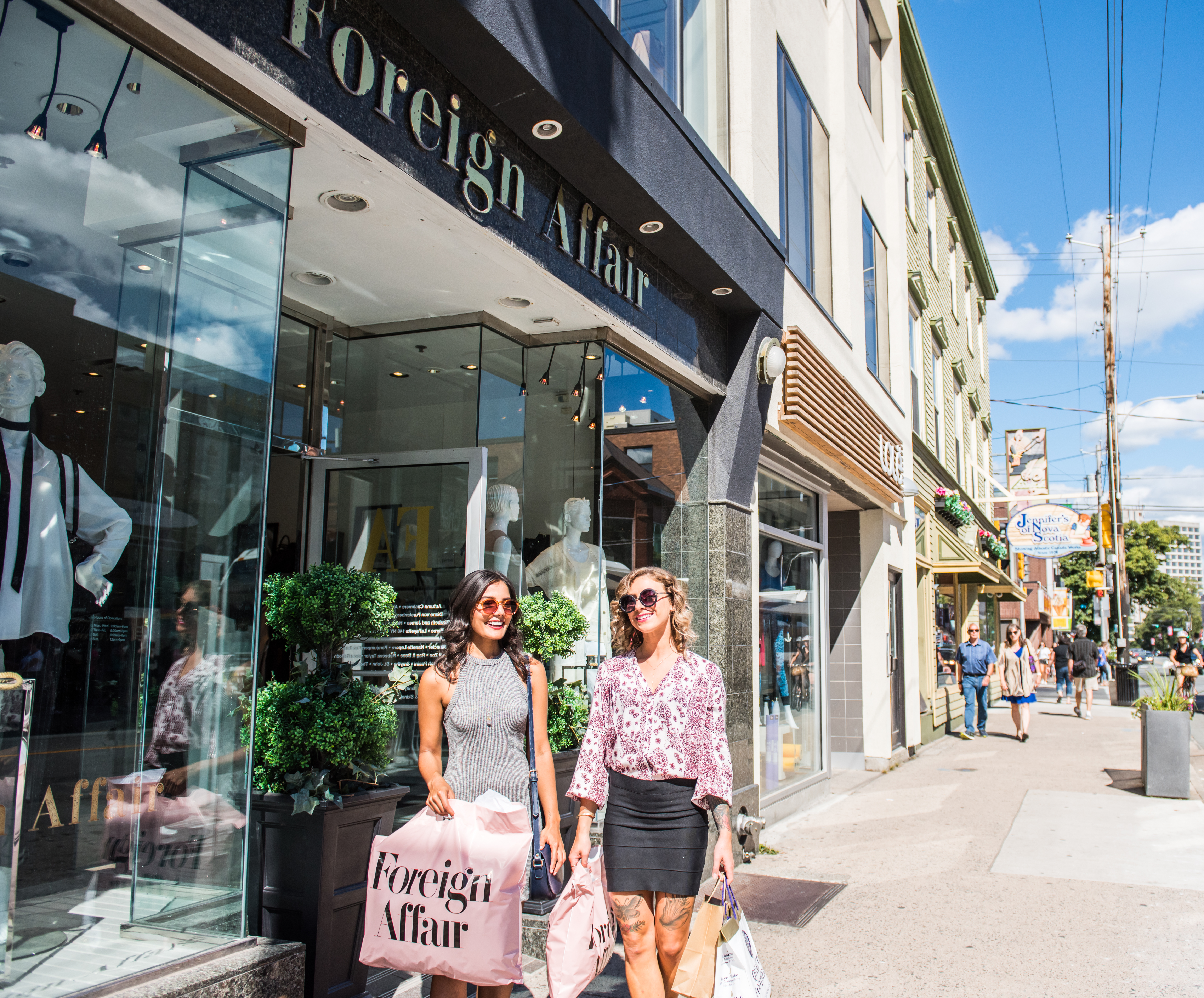 Two women walking with shopping bags on a sunny day