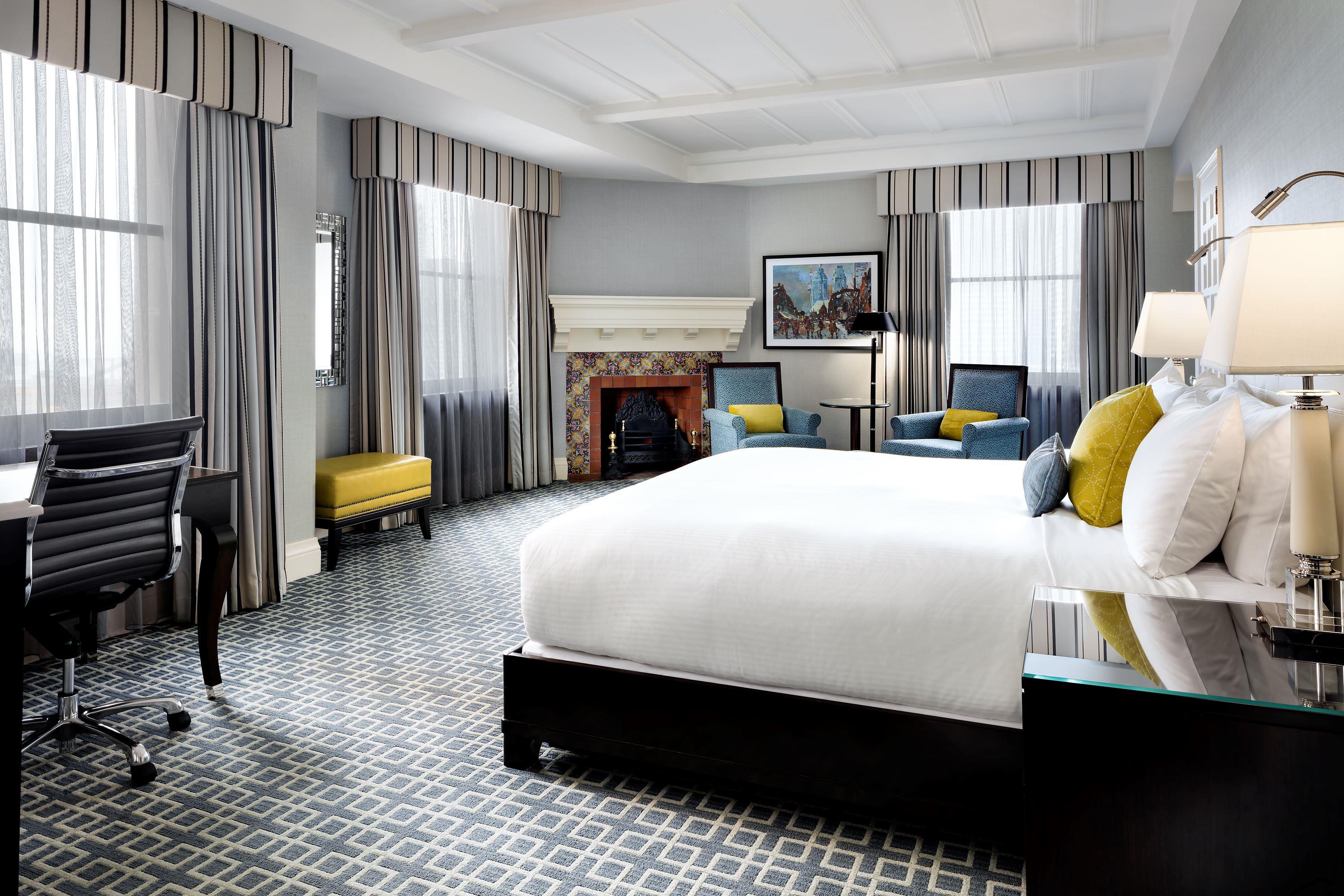 Luxury hotel room with a fireplace and large windows at the Fairmont Royal York 