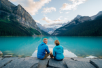 A couple enjoying the view of the mountains and water in Lake Louise