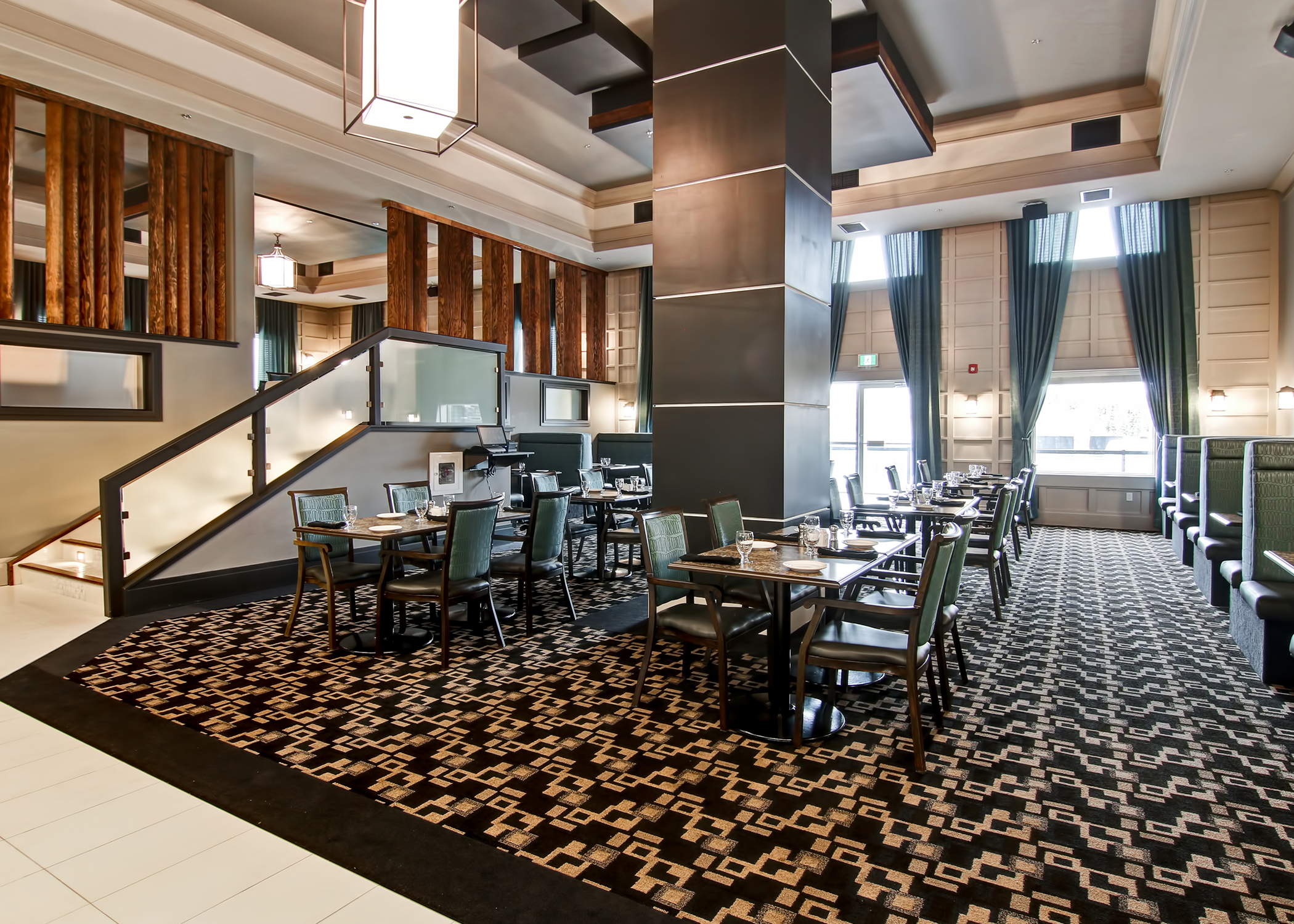 Hotel lobby with natural light laid out with seating and tables in carpeted area