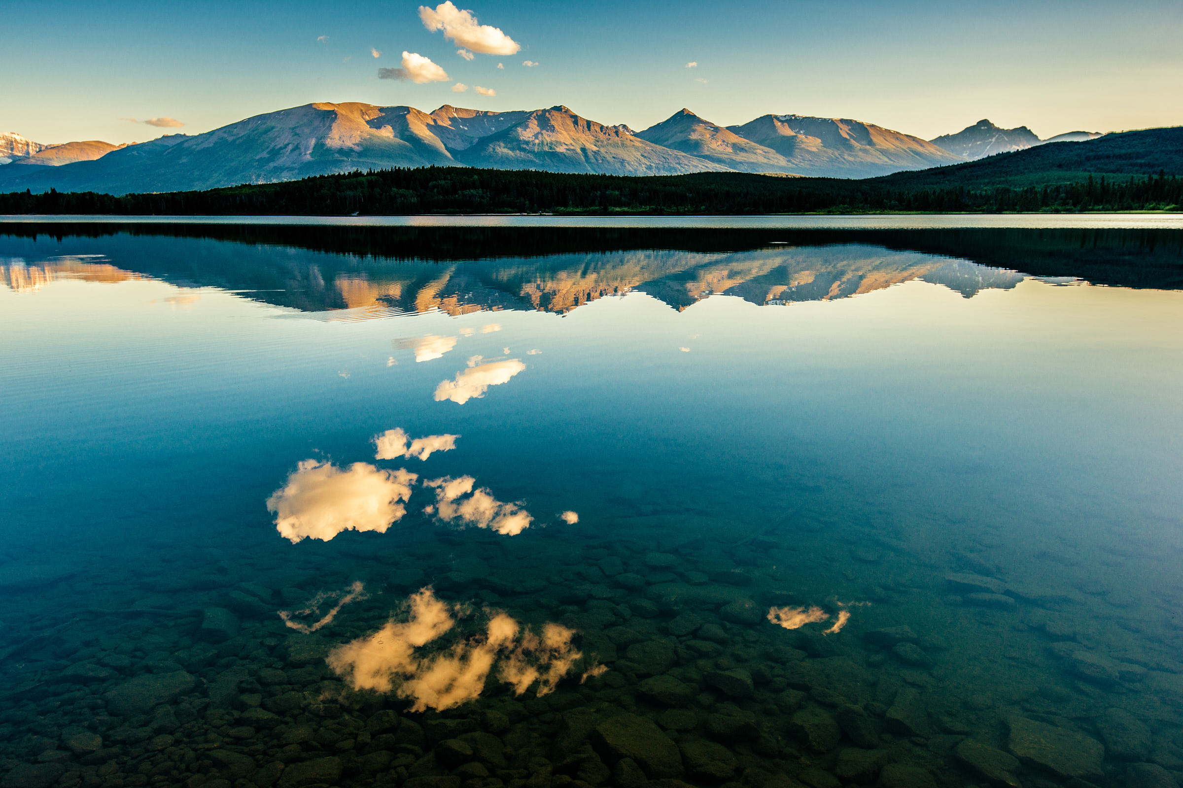 Clouds in the sky reflecting in Pyramid Lake and mountain range behind