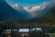 Wooden mountain lodge surrounded by mountains.