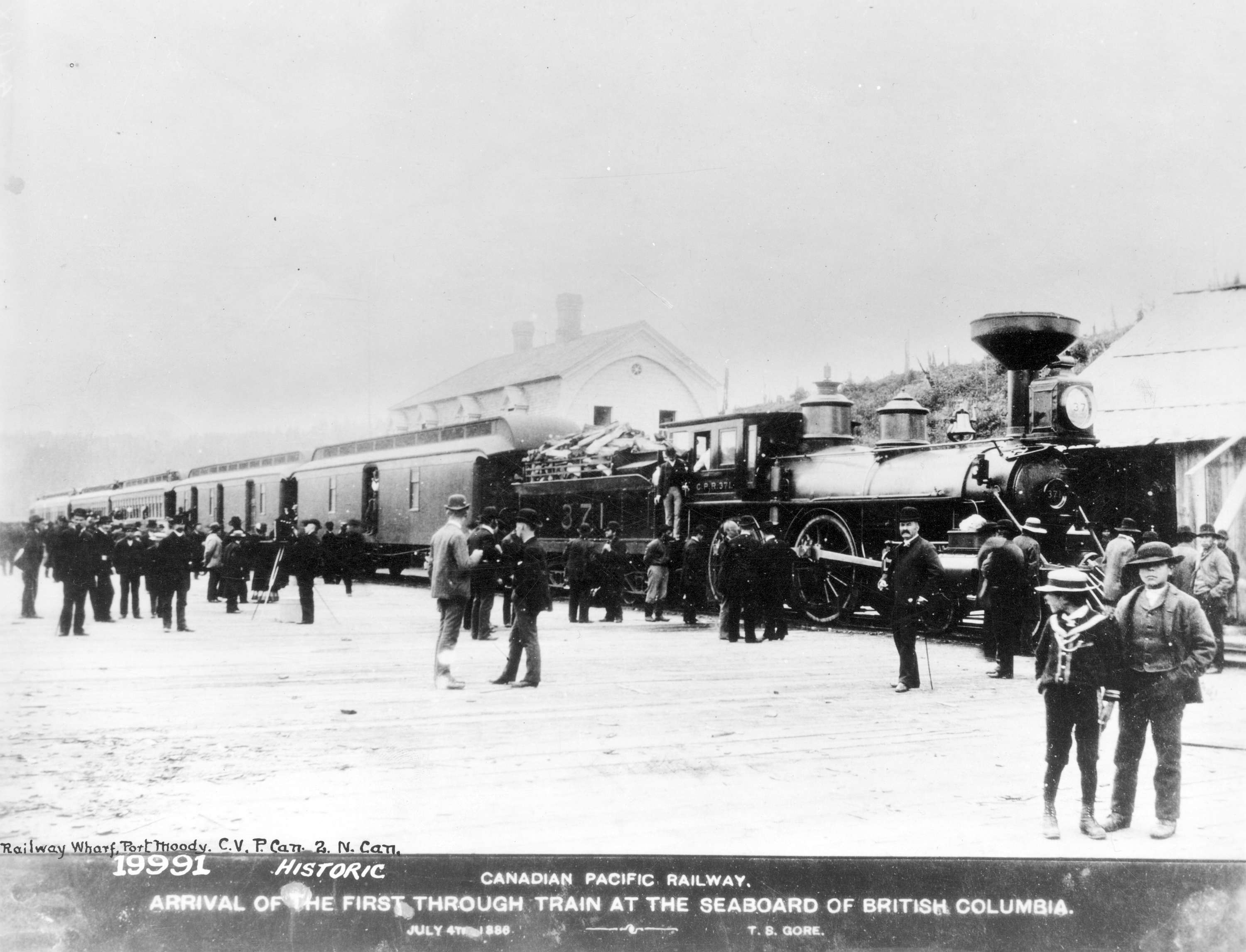 Men next to C.P.R. locomotive 371 at the Port Moody railway station.